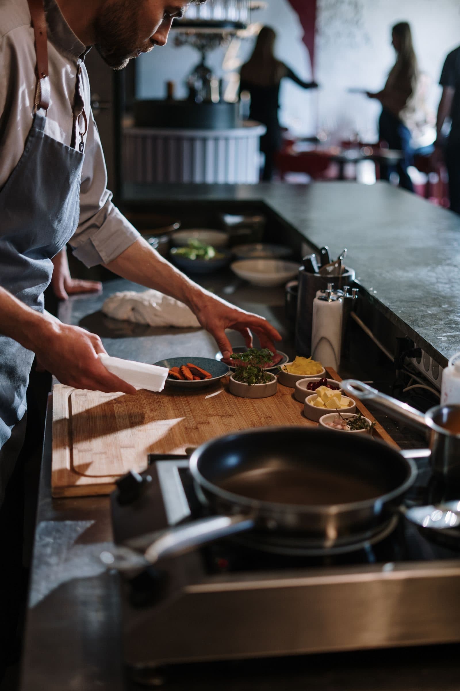 A cook plating dishes at a restaurant counter